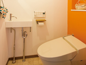 オレンジ色の壁や洗面台などこだわりの詰まったトイレになりました。